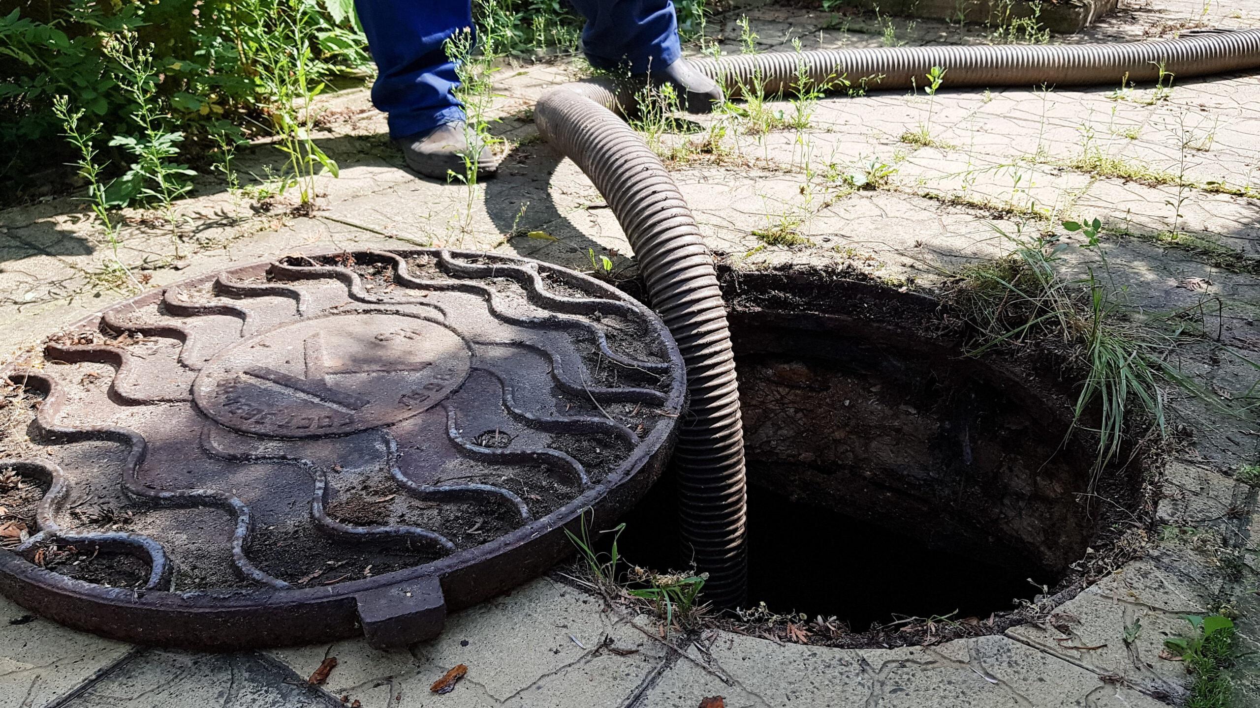 the worker opened the sewer hatch and inserted a hose for cleaning the septic tank.