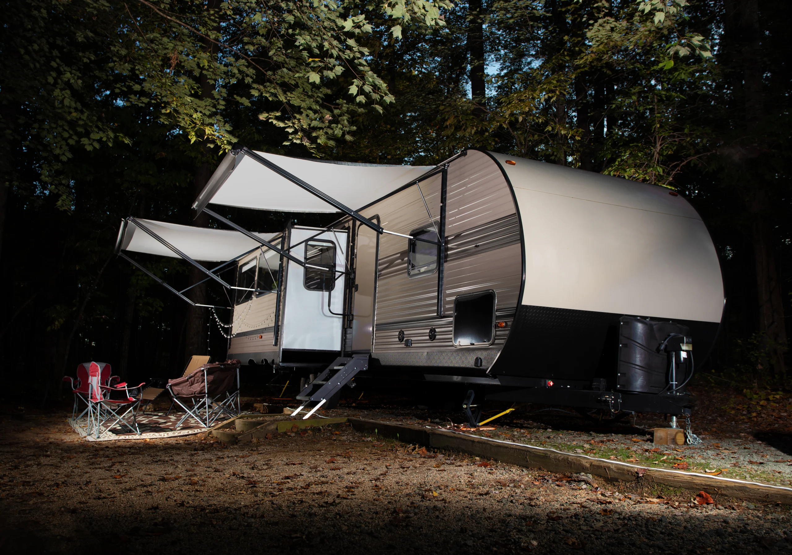 Travel trailer in early autumn set up at a campsite.